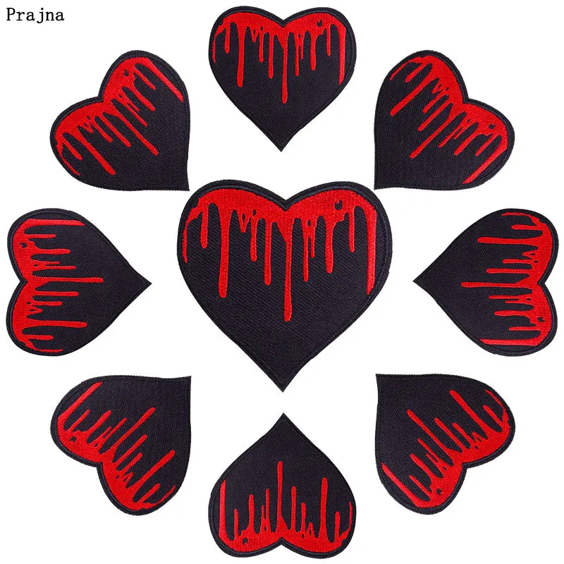 A set of ten black heart-shaped iron-on patches with red dripping designs.