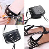 Black faux leather clutch purse decorated with silver metal spike studs and chain details