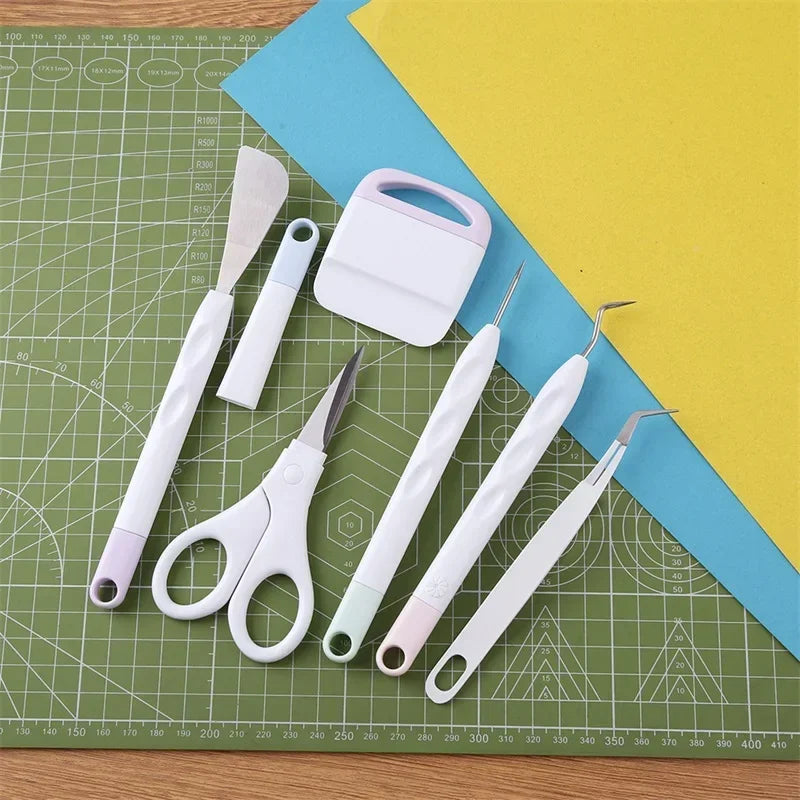 A set of six vinyl weeding and craft tools including nippers, tweezers, and other precision DIY instruments on a green mat.