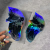 A waterproof vinyl skull decal featuring a vibrant iridescent blue and purple glow on a clear background.