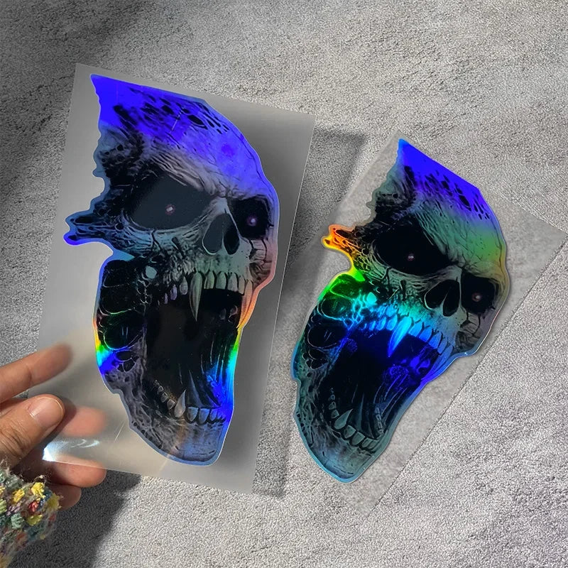 A waterproof vinyl skull decal featuring a vibrant iridescent blue and purple glow on a clear background.