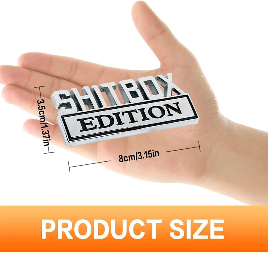 Eine Hand hält ein Set aus 3D-Aufklebern (Decals) der Shitbox Edition in Schwarz und Weiß für das Auto.