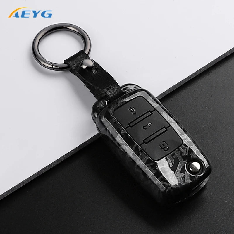 A black carbon fiber car key cover with a metal keyring and electronic features for VW and Skoda models