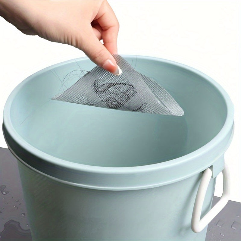 A hand is placing a mesh filter hair catcher into a light blue plastic drain bucket.