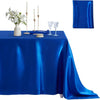 A royal blue satin tablecloth set for dining or events, featuring a navy napkin, candles, and glassware.