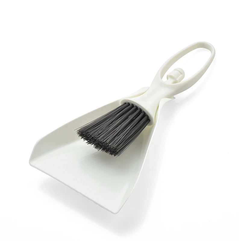 A white compact mini broom and dustpan set with a handle and bristles for cleaning desks and keyboards.