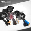 Three stainless steel bottomless espresso portafilters with colored handles displayed on a white background.