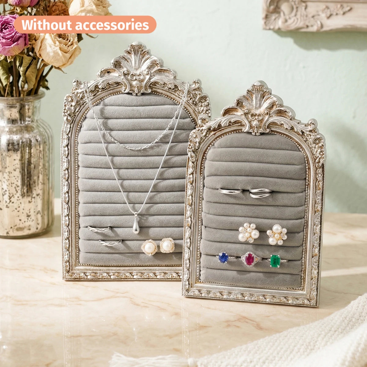 Silver arched resin jewelry display stand with floral design featuring various necklaces and earrings.