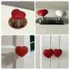 A heart-shaped toilet flush button with a silver base and nail protector, shown in various views.