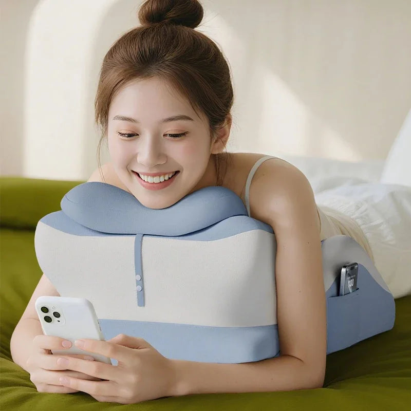 A woman is using a light blue memory foam full-body support pillow for sleeping, reading, or gaming.