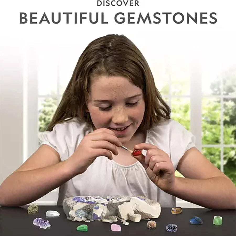 A girl is excavating colorful gemstones from a rock in a clear container.
