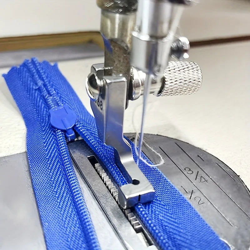 Stainless steel invisible zipper presser foot attached to a sewing machine needle and blue fabric.