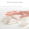 A hand is pressing into a white, fluffy memory sponge or bath mat to demonstrate its soft rebound and absorbency.