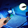 A hand holds a remote control for an RGB LED car interior ambient light kit with music sync and remote control installed in a