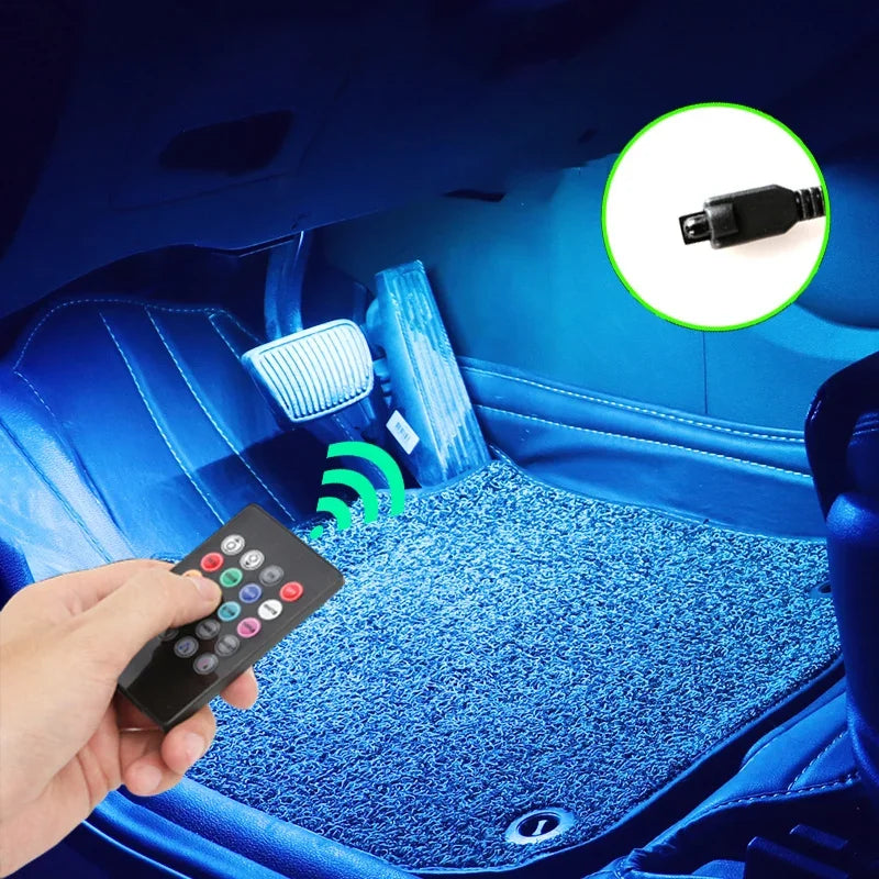 A hand holds a remote control for an RGB LED car interior ambient light kit with music sync and remote control installed in a