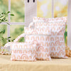 A set of reusable waterproof wet bags featuring a rainbow pattern displayed on a light beige surface.