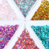 A collection of shiny holographic star sequins in various colors arranged in a square box.