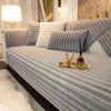 A modern gray sofa with textured cushions and a gold decorative item on the surface.