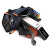 A navy blue tactical chest bag is shown open, containing a smartphone, sunglasses, and a wristwatch.