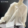 A white, long-sleeved blouse is displayed on a mannequin.