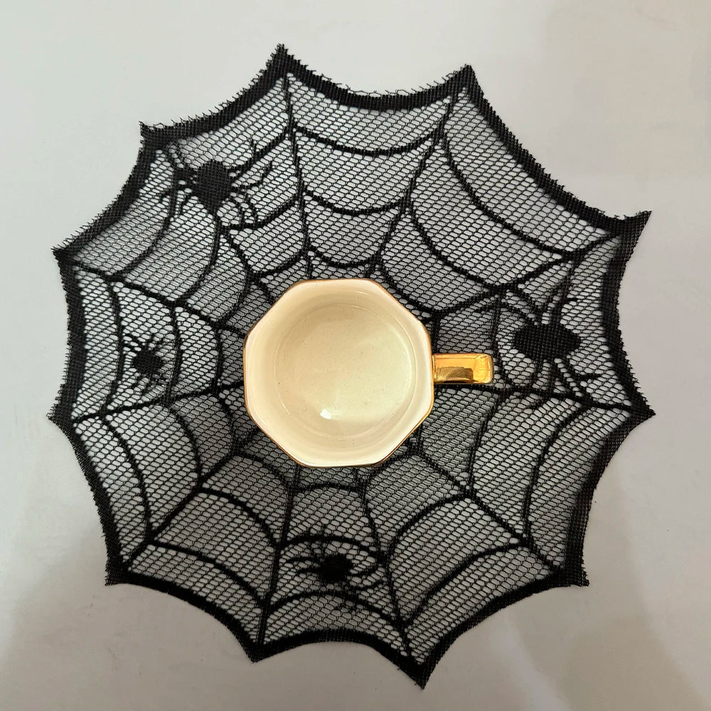 A black, decorative spider web mesh placemat with a small white bowl on a light surface.