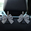 Black car seat back hook featuring a bow-shaped storage accessory.