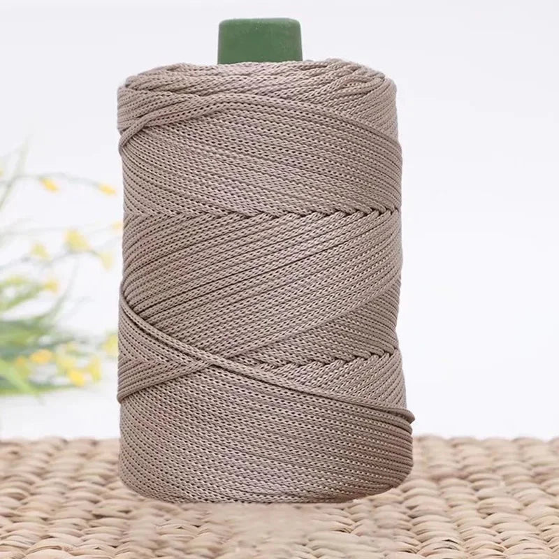Spule beiger Eis-Seil-Kordel für DIY-Bastelarbeiten auf einer geflochtenen Matte.