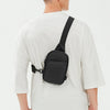 A man wearing a white t-shirt is shown from the back, carrying a black 2-in-1 convertible waist and crossbody sling bag.
