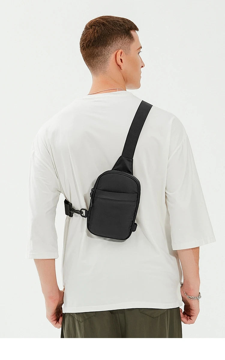 A man wearing a white t-shirt is shown from the back, carrying a black 2-in-1 convertible waist and crossbody sling bag.