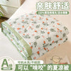 A quilted white blanket with a floral pattern is shown folded on a bed, emphasizing its light and breathable comfort.