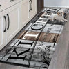 A long kitchen mat featuring black lettering and wood grain patterns placed on a light wooden floor.