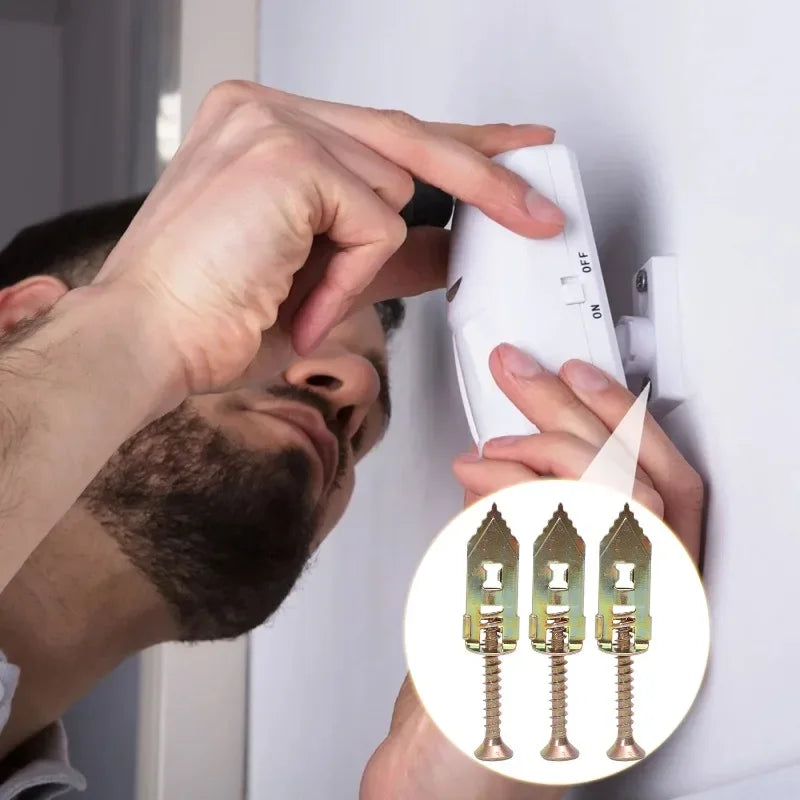 A hand is installing a heavy duty self-drilling drywall anchor into a wall, showing the anchor's design.