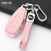 Pink silicone car key fob cover with a silver chain attached, shown on a black surface.