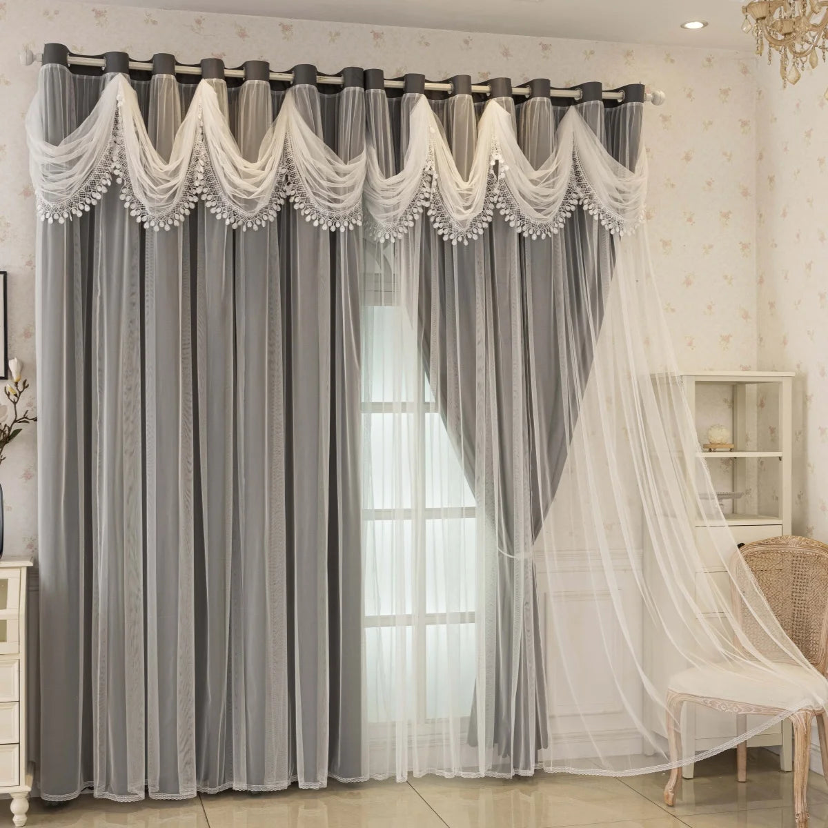 Gray sheer curtains with white lace trim and dual layers blocking light in a room.