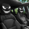 Two black car headrest covers featuring an evil grin design on a black leather seat.