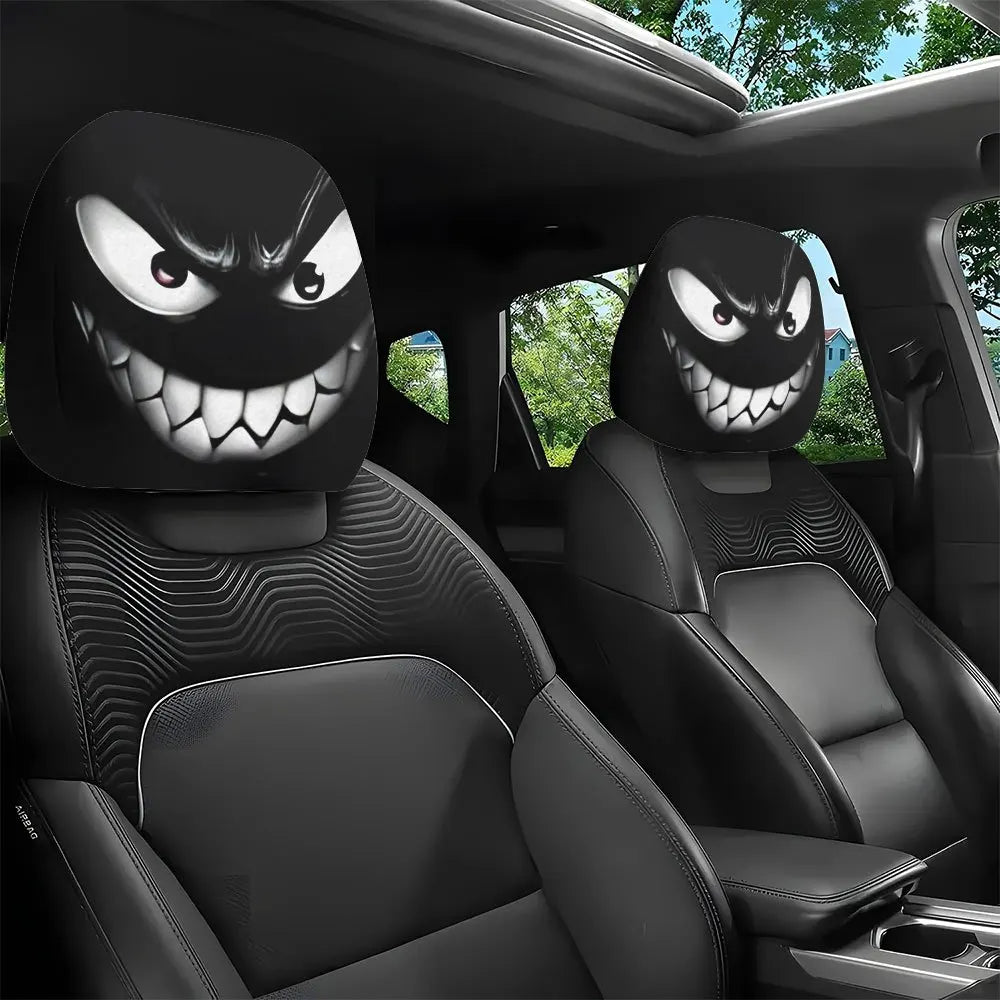 Two black car headrest covers featuring an evil grin design on a black leather seat.