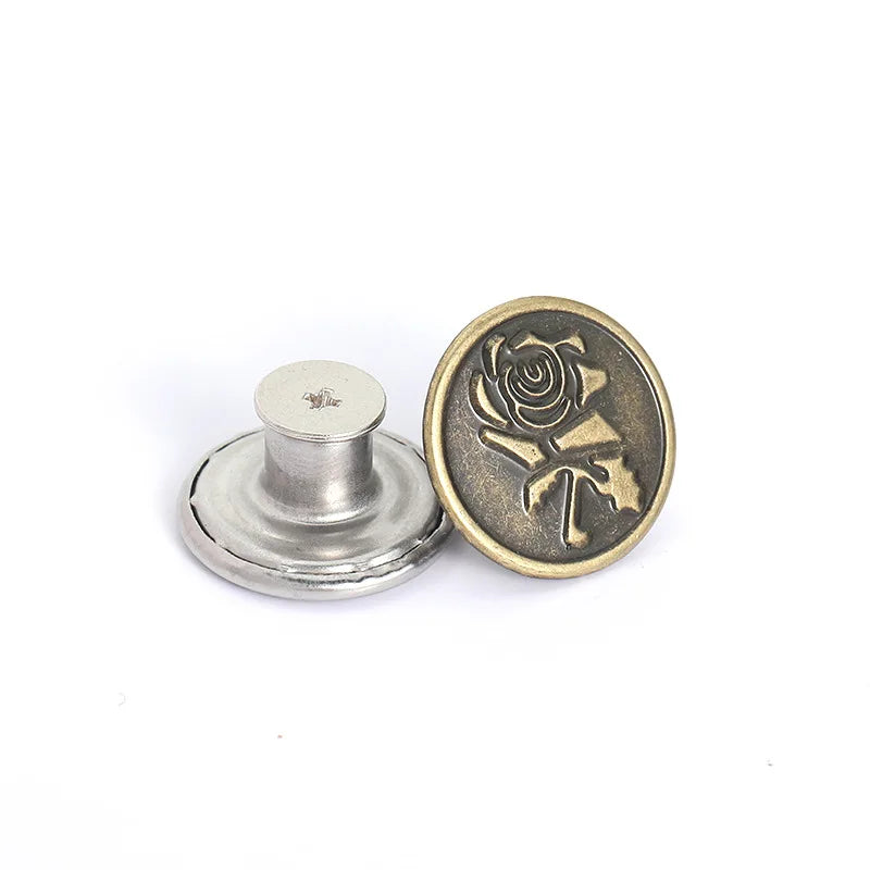 A round brass button with a detailed rose design and a silver button base.