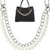 Black leather purse with a gold chain and pearl necklace displayed against a white background.