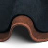 A custom fit dashboard sun shield in black fabric with a brown trim, shown from the underside.