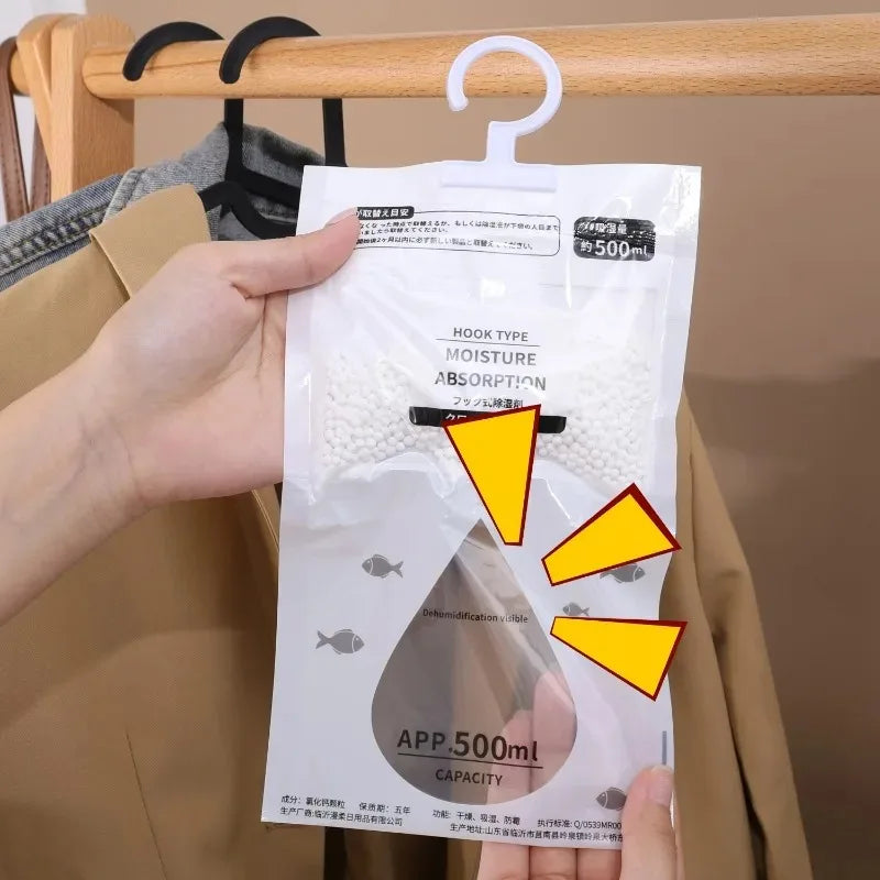 A white moisture absorber bag with a hook is hanging on a wooden hanger in a closet setting.