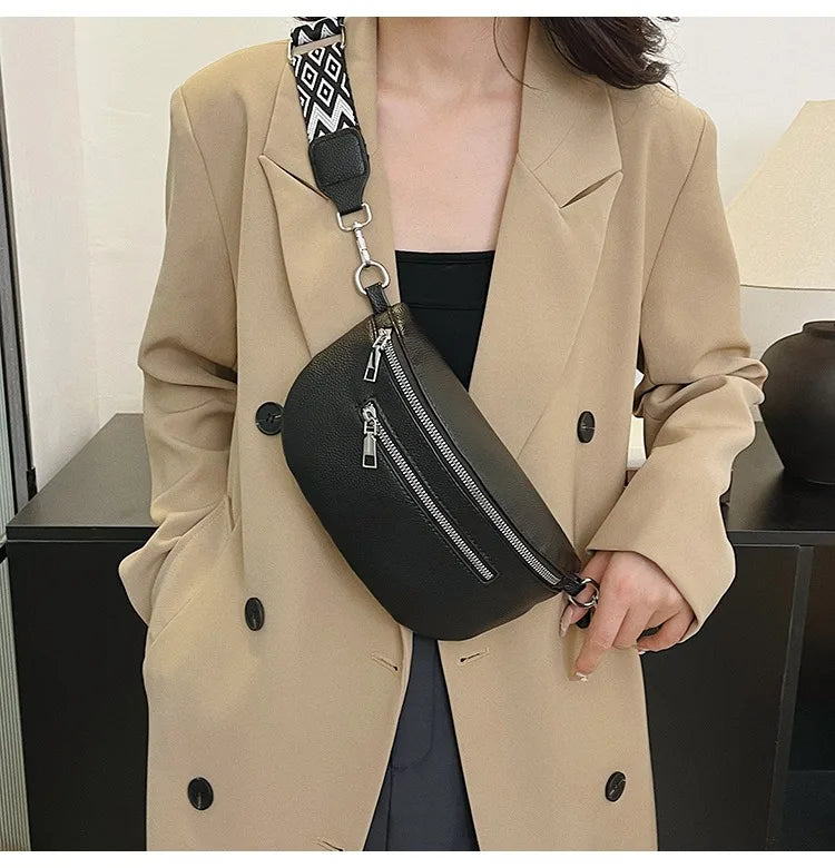 A woman wearing a beige blazer holds a black multi-pocket PU leather waist bag with an adjustable strap.
