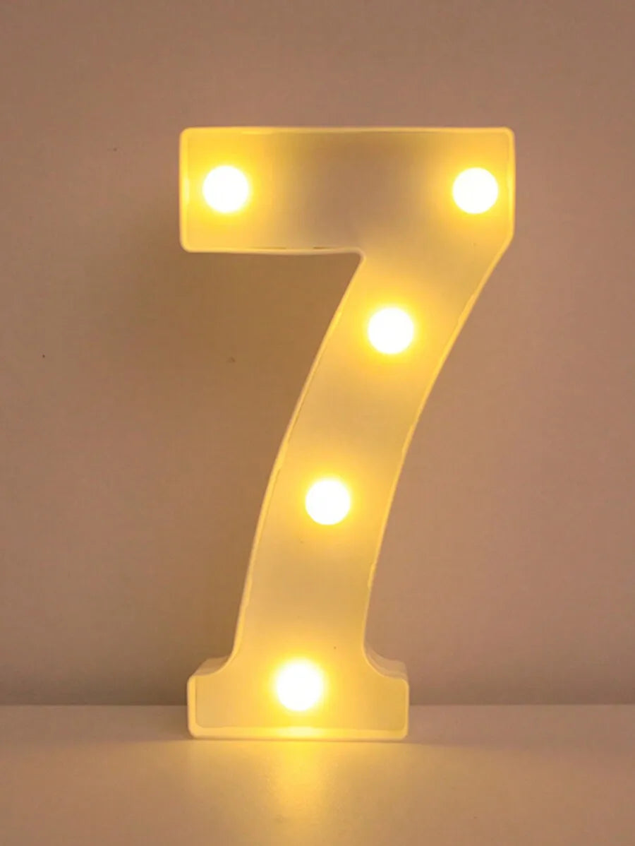 A glowing yellow LED letter light shaped like the number seven, used for home and party decor.