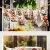 A display of floral collage style vintage botanical washi tape strips hanging on a twine against a blurred outdoor background