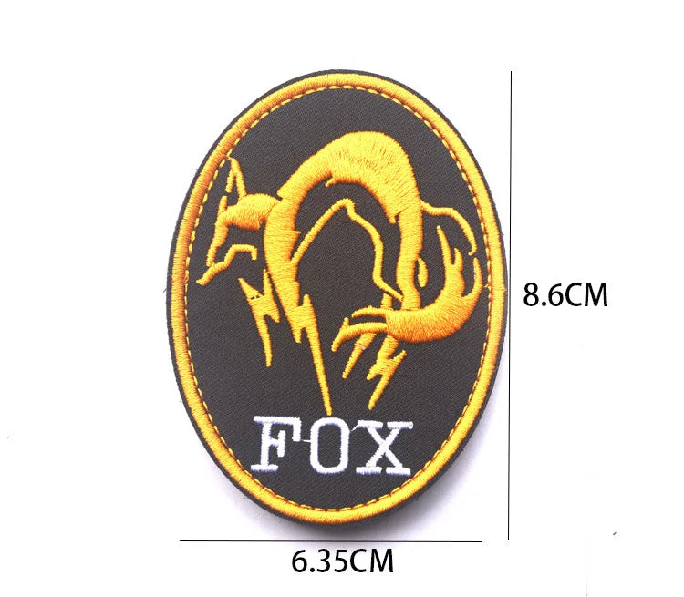Black embroidered patch featuring a golden fox head with lightning and the word FOX in silver thread.