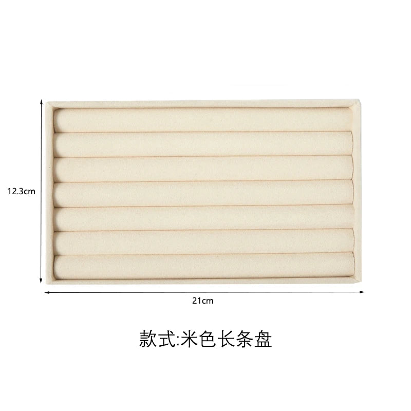 A rectangular velvet jewelry organizer tray with multiple long compartments.