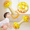 A baby is interacting with an orange and yellow sensory spinning rattle toy set.