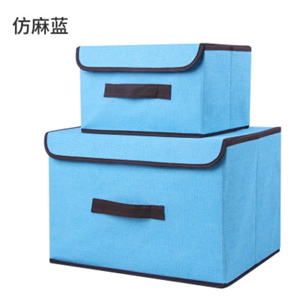 A set of two light blue fabric storage boxes with black trim for closet and drawer organization.