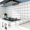 A kitchen splashback featuring white subway tiles, a stainless steel hood, and a roll of self-adhesive backsplash sticker.