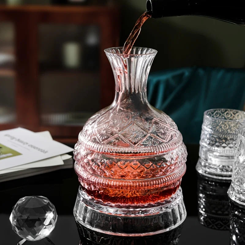 A handcrafted crystal wine decanter is being poured into a glass, showing its intricate design and reddish-pink hue.