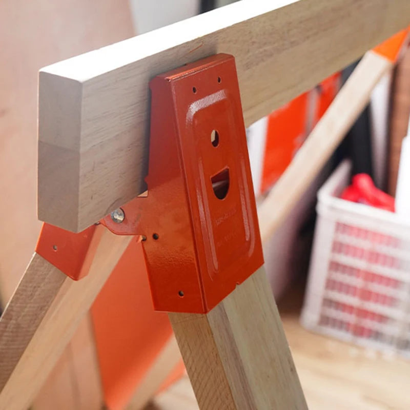 Close-up of an orange steel bracket attached to a light wood workbench frame.